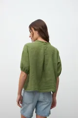 Camisa verde oliva de lino, con cuello mao y mangas cortas abullonadas.