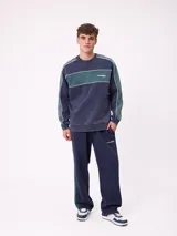 Pantalón tipo babucha de la marca Rusty, color azul petróleo con franjas laterales en color bordó. Presenta cintura elástica con cordón ajustable y logo bordado en la pierna izquierda.