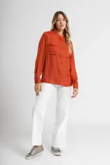 Camisa verde con cuello mao, de manga larga con puños abotonados y cierre frontal con botones.