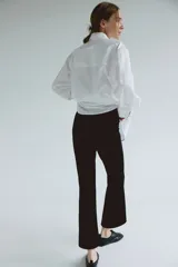 Pantalón tobillero de maternidad en punto interlock pesado color negro, de tiro alto con elástico oculto, pinzas en la parte trasera y piernas ajustadas con bajo acampanado.