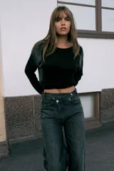 Jersey de punto con cuello redondo amplio y manga larga, presentando un efecto difuminado o degradado en tonos oscuros, posiblemente negro y gris.