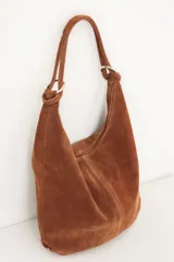 Bolso hobo de cuero gamuzado color marrón, con correa de hombro y cierre superior.