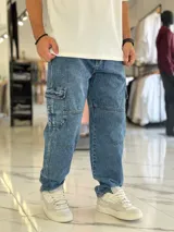 Pantalón cargo de jean azul con múltiples bolsillos en los laterales y diseño holgado.