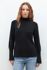 Polera de punto color ladrillo, de cuello alto y mangas largas con cierre en los puños.