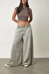 Jean de corte wide leg y tiro bajo, en color gris claro con efecto acid wash, cintura elastizada y bolsillos.