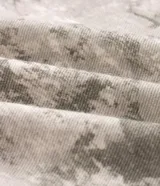 Pantalón de sarga de algodón con corte super baggy, tiro bajo y piernas ultra amplias. Presenta un estampado integral con efecto marmorizado o dirty, bolsillos utilitarios laterales, bolsillos frontales y traseros, cintura con pasantes y cierre frontal con botón y cremallera.