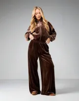 Conjunto de dos piezas de terciopelo color chocolate, compuesto por una campera oversized con cierre frontal y un pantalón wide leg de tiro alto con cintura elastizada.
