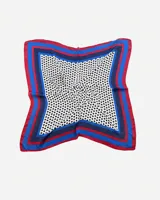 Pañuelo cuadrado de tela fina color blanco con lunares negros. Tiene un borde con franjas de color azul, rojo y azul marino.