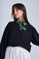 Blusa negra de mangas largas abullonadas y cuello redondo.