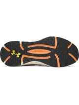 Championes Under Armour Phantom X, de color gris con detalles en naranja y suela blanca y negra. Presentan una estructura de soporte lateral semitransparente con el logo de la marca y cordones con detalles amarillos.