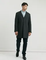 Sobretodo 3/4 de paño, color gris oscuro, con cuello solapa, cierre frontal de botones, manga larga y bolsillos laterales de ribete.