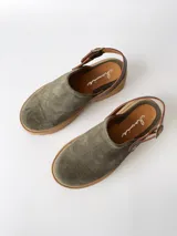 Zuecos de cuero color verde seco, con hebilla lateral y suela de goma.