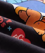 Remera boxy de algodón gris oscuro, con cuello redondo, mangas cortas y estampa localizada en el pecho con personajes de Los Cariñositos y Hello Kitty interactuando con estrellas.