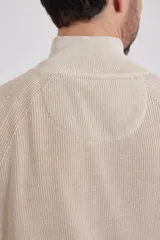 Cardigan azul de tejido de punto con cierre frontal y cuello alto.