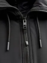 Campera anorak técnica de Jack & Jones, diseñada para ski, en color negro. Presenta cierre frontal parcial, capucha ajustable con cordones, puños con ajuste de velcro y detalles gráficos estampados en el pecho. Confeccionada en tejido impermeable y cortaviento con forro interior para mayor abrigo.