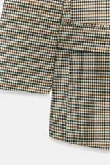 Blazer marrón de cuello solapa con muescas, manga larga y bolsillos de vivo con solapa. Cierre frontal con un botón.