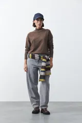 Polera de tejido de punto color marrón, con cuello alto y diseño de rombos en relieve en el frente. Presenta mangas largas con puños acanalados y un calce relajado.