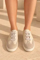 Championes de cuero vacuno color celeste con puntera de gamuza marrón, suela de goma y cordones elásticos.