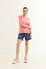 Sweater rosado de tejido de punto con escote en V y mangas largas con puños acanalados. El ruedo también es acanalado y presenta un detalle de crochet.