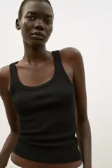 Musculosa de punto rib color blanco, con escote redondo y diseño ajustado.