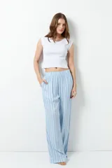 Pantalón de pijama celeste con rayas verticales finas color marrón, con bolsillos laterales y elástico en la cintura.