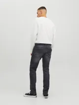 Jean de corte slim con tiro bajo, confeccionado en denim de color negro con efecto lavado. Presenta diseño clásico de cinco bolsillos y cierre frontal con botón.
