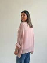Sweater de punto en color rosado, con diseño holgado, cuello redondo y mangas murciélago anchas con vuelta.