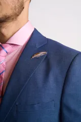 Ambo de corte entallado compuesto por saco de dos botones y pantalón de vestir a juego, en color azul. El saco presenta solapas clásicas y bolsillos con solapa, mientras que el pantalón tiene un corte recto y limpio.