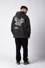 Buzo canguro con capucha, de calce oversize y efecto de lavado ácido en tono marrón. Presenta un bolsillo frontal tipo canguro y un pequeño estampado minimalista en el pecho.