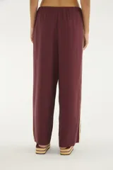 Pantalón negro de silueta amplia y caída relajada, con cintura elástica ajustable mediante cordón blanco y detalles de vivos laterales en color blanco.