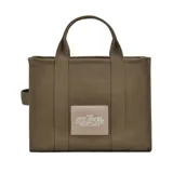 Bolso tote de lona color negro con estampado frontal en blanco que reza 'THE TOTE BAG MARC JACOBS'. Cuenta con doble asa superior, cierre de cremallera y correa larga ajustable y extraíble.