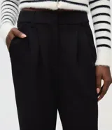 Pantalón wide leg de modal color beige, con tiro alto, pliegues delanteros y bolsillos laterales tipo cuchillo. Cuenta con trabillas en la cintura.