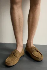 Zapato estilo náutico fabricado en piel con acabado serraje, con detalle de bordón en el empeine, horma redonda y suela ultrafina a contraste.