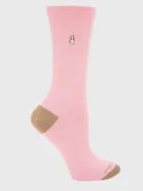 Calcetín de mujer color rosado, largo medio, con puntera y talón en color marrón. Presenta un bordado de perro de raza Basset Hound en la caña.