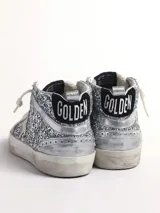 Zapatillas deportivas de caña media Golden Goose modelo Mid Star, cubiertas de glitter plateado, con detalles en cuero plateado y estrella lateral en cuero blanco.