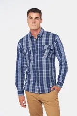 Camisa de franela a cuadros azul y blanco, de manga larga, con dos bolsillos frontales con solapa abotonada.