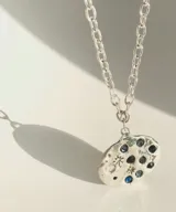 Collar plateado con dije irregular con incrustaciones de strass azules y transparentes.