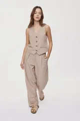 Pantalón sastrero negro de pierna amplia, tiro medio, con cintura con pasacintos, bolsillos laterales y cierre frontal con botón y cremallera.
