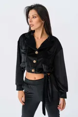 Campera corta color negro de terciopelo con cuello clásico, cierre frontal con botones dorados, mangas largas con puños elásticos, dos bolsillos frontales con solapa y lazo ajustable en la cintura.