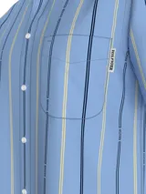 Camisa celeste de Tommy Hilfiger con rayas verticales azules y amarillas, de corte regular, manga corta, cuello abotonado, bolsillo de parche en el pecho y logo bordado en la manga.