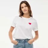 Camiseta de manga corta color blanco con cuello redondo y pequeño corazón rojo estampado en el pecho.