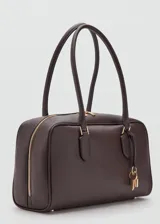Bolso de mano de poliuretano color marrón oscuro, con doble asa para el hombro, herrajes metálicos dorados y detalle de llavero decorativo con candado y llaves.