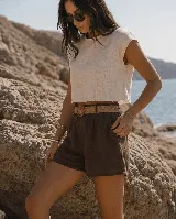 Short de lino color azul marino, de tiro alto, con bolsillos laterales y e incluye un cinto de rafia con hebilla redonda.