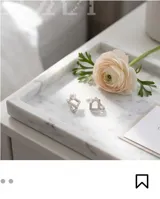 Aros tipo argolla con diseño geométrico en forma de rombo, engastados con pequeñas circonias brillantes y rematados con una perla blanca. Fabricados en plata 925.
