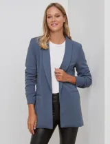 Blazer de crep azul, marca BBJ, con cuello solapa, bolsillos delanteros y mangas tres cuartos con frunce.