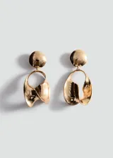Aros colgantes dorados de diseño geométrico y orgánico, formados por un disco superior texturizado y una pieza inferior de forma ovalada e irregular con efecto drapeado.