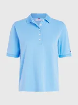 Chomba celeste de piqué de algodón con cuello ribeteado, cartera de cinco botones, logo de Tommy Hilfiger bordado en el pecho y bandera de Tommy Hilfiger bordada en la manga.