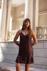 Vestido corto de lentejuelas color chocolate, con breteles finos, escote en V y volado en el ruedo.