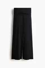 Pantalón negro de punto fino suave con piernas amplias y tiro alto. Presenta una cintura ancha con costuras laterales fruncidas para crear un efecto drapeado.