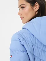 Campera puffer celeste con capucha y cierre frontal con cremallera.